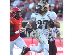 University of Calgary Dinos defensive back Elie Bouka, left, can only watch as Kienan LaFrance of the Manitoba Bisons runs in for a touchdown Sept. 26 at McMahon Stadium.