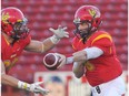 University of Calgary Dinos quarterback Andrew Buckley makes a first quarter handoff against the Manitoba Bisons Sept. 26, 2014 at McMahon Stadium.