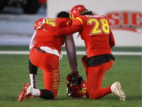 Calgary Dinos Elie Bouka, left and Hunter Turnbull console each other after losing the 2014 Canada West Hardy Cup to the Manitoba Bisons.