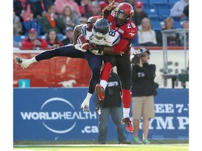 The Toronto Argonauts' Trent Guy, left, and Calgary Stampeders defensive back Brandon Smith collide during their game at McMahon Stadium in Calgary on Sept. 13.