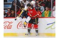 Michael Ferland of the Calgary Flames checks Anton Volchenkov of the Nashville Predators into the boards at Scotiabank Saddledome on Friday night. Volchenkov later delivered a forearm to the head of Ferland, which left the rookie concussed and the Predator suspended for four games.