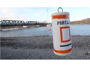The existing portage markers hang over the Bow River above Harvie Passage warning of the danger downstream as seen November 5, 2014. The rafting channel at the passage was completely destroyed in the flood of 2013.