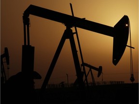 Oil pumps work at sunset in the desert oil fields of Sakhir, Bahrain.