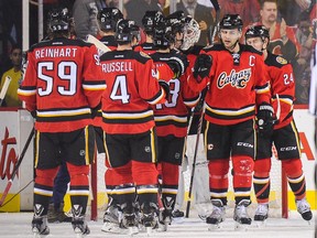 CALGARY, AB - NOVEMBER 15: Mark Giordano #5 of the Calgary Flames celebrates with his teammates after defeating the Ottawa Senators during an NHL game at Scotiabank Saddledome on November 15, 2014 in Calgary, Alberta, Canada. The Flames defeated the Senators 4-2.