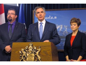 Alberta Premier Jim Prentice (centre) announces Monday, Nov.24, 2014 at the legislature in Edmonton that opposition Wildrose members Ian Donovan, left, and Kerry Towle, right, have crossed the floor to join his Progressive Conservative caucus.