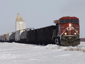 Grain and oil rail cars pass by a grain elevator in Rosser, Man., March 24, 2014.