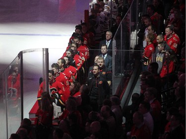 Members of the Calgary Flames stood on the bench during the national anthems at the Scotiabank Saddledome on November 20, 2014.