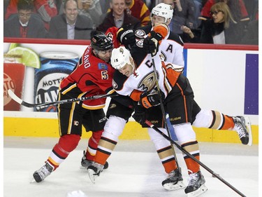 Colleen De Neve/ Calgary Herald CALGARY, AB --NOVEMBER 18, 2014 -- Calgary Flames defenceman Mark Giordanno, left, stopped Anaheim Ducks centre Ryan Getzlaf, foreground, and right winger Corey Perry during first period NHL action at the Scotiabank Saddledome on November 18, 2014. (Colleen De Neve/Calgary Herald) (For Sports story by Scott Cruickshank) 00056694A  SLUG: 1119-Flames Ducks