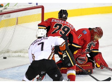 Colleen De Neve/ Calgary Herald CALGARY, AB --NOVEMBER 18, 2014 -- Calgary Flames goalie Jonas Hiller peered down as a shot by the Anaheim Ducks snuck past him into the net as defenceman Deryk Engelland and Ducks centre Andrew Cogliano watched during first period NHL action at the Scotiabank Saddledome on November 18, 2014. (Colleen De Neve/Calgary Herald) (For Sports story by Scott Cruickshank) 00056694A  SLUG: 1119-Flames Ducks