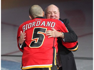 Colleen De Neve/ Calgary Herald CALGARY, AB --NOVEMBER 18, 2014 -- Longtime Calgary Flames play by play man Peter Maher was welcomed to the ice by Flames Captain Mark Giordanno during his pre game tribute prior to the Flames tilt against the Anaheim Ducks at the Scotiabank Saddledome on November 18, 2014. (Colleen De Neve/Calgary Herald) (For Sports story by Scott Cruickshank) 00056694A  SLUG: 1119-Flames Ducks