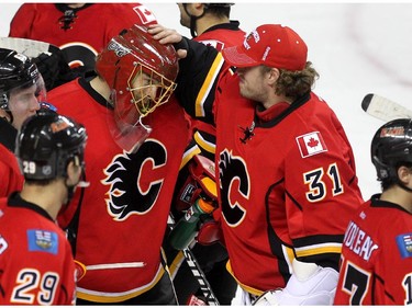 Colleen De Neve/ Calgary Herald CALGARY, AB --NOVEMBER 18, 2014 -- Calgary Flames back up goalie Karri Ramo, right, congratulated goalie Jonas Hiller after the Flames defeated the Anaheim Ducks 4-3 in overtime in NHL action at the Scotiabank Saddledome on November 18, 2014.  (Colleen De Neve/Calgary Herald) (For Sports story by Scott Cruickshank) 00056694A  SLUG: 1119-Flames Ducks