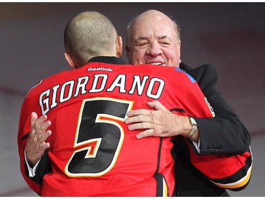 Longtime Calgary Flames play by play man Peter Maher was welcomed to the ice by Flames Captain Mark Giordanno during his pre game tribute prior to the Flames tilt against the Anaheim Ducks at the Scotiabank Saddledome on November 18, 2014.
