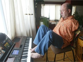 Alvin Law plays piano with his toes in his Calgary home. Law was a Thalidomide baby, born without arms. Law and others deserve compensation for their disabilities.