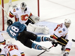 Calgary Flames goalie Karri Ramo stares down San Jose's Tomas Hertl as he gets tripped on a shot attempt in front of the net by captain Mark Giordano. Ramo made 32 saves for a 2-0 shutout win.