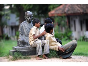 Indian children play near the statue of Mahatma Gandhi in 2009. The Indian independence leader once counselled that "the best way to find yourself is to lose yourself in the service of others."