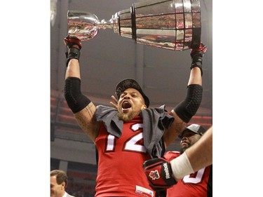 The Calgary Stampeders Juwan Simpson holds the Grey Cup after the team won the 2014 Grey Cup in Vancouver on Sunday November 30, 2014.