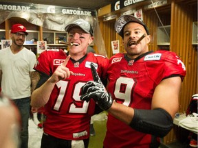 Jon Cornish #9 of the Calgary Stampeders and Bo Levi Mitchell #19 celebrates in the dressing room after defeating the Hamilton Tiger-Cats to win the 102nd Grey Cup Championship Game at BC Place November 30, 2014 in Vancouver, British Columbia, Canada.