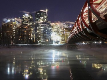 The Peace Bridge reaches over the misty Bow River leading towards the welcoming glow of the warm downtown core lights on a bone chilling evening in Calgary, on November 29, 2014.
