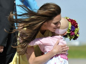 Catherine, the Duchess of Cambridge is presented with flowers and a hug by 6-year-old Diamond Marshall on arrival with Prince William at Calgary International Airport in Calgary on July 7, 2011. The Children's Wish Foundation arranged for Marshall, a cancer patient, to greet the royal couple.