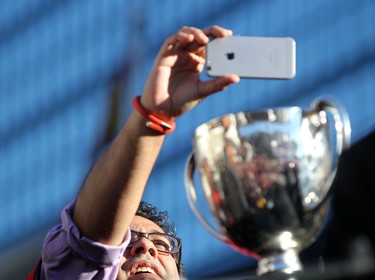 Calgary mayor Naheed Nenshi takes a photo of the Grey Cup during the Grey Cup Champions rally at City Hall in Calgary.