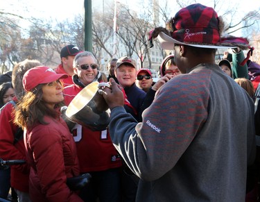 Calgary Stampeders Nik Lewis shows fans the grey Cup during the Grey Cup Champions rally at City Hall in Calgary.