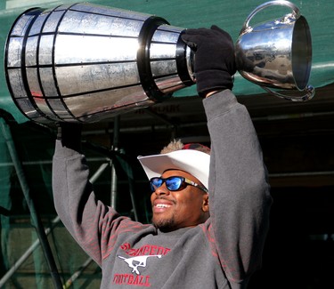 Calgary Stampeders Nik Lewis holds the grey Cup during the Grey Cup Champions rally at City Hall in Calgary.
