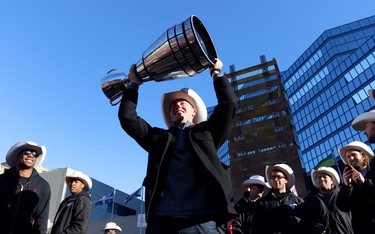 Calgary Stampeders quarterback Bo Levi Mitchell hoists the Grey Cup during the Grey Cup Champions rally at City Hall in Calgary.