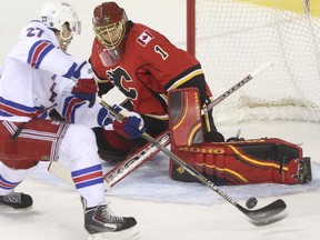 Calgary Flames goalie Jonas Hiller stones New York Rangers' Derek Stepan during Tuesday's game. Calgary's NHL team lost 5-2, their sixth straight.