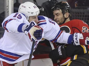 Crystal Schick/ Calgary Herald CALGARY, AB -- Calgary Flames Deryk Engelland takes a hit from New York Rangers Tanner Glass during third period action at the Scotiabank Saddledome in Calgary, on December 16, 2014. --  (Crystal Schick/Calgary Herald) (For Sports story by  TBA) 00056716A