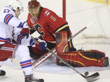 Calgary Flames goalie Jonas Hiller stones New York Rangers Derek Stepan during second period action at the Scotiabank Saddledome in Calgary, on December 16, 2014.