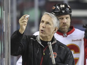 Calgary Flames head coach Bob Hartley draws out a drill on the boards during team practice at the Saddledome on Thursday, a day after he received a multi-year contract extension from the NHL club.