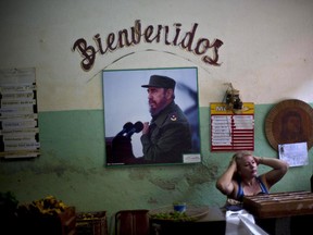 A photograph of Fidel Castro hangs under the Spanish word for "Welcome" on the wall at a state-run food market in Havana, Cuba.