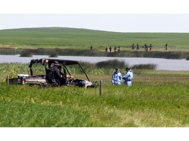 Police Ident members made their way into the search area at a slough near the Airdrie search area in connection with the disappearance of Nathan O'Brien, 5, Alvin Liknes and Kathryn Liknes on July 6, 2014.