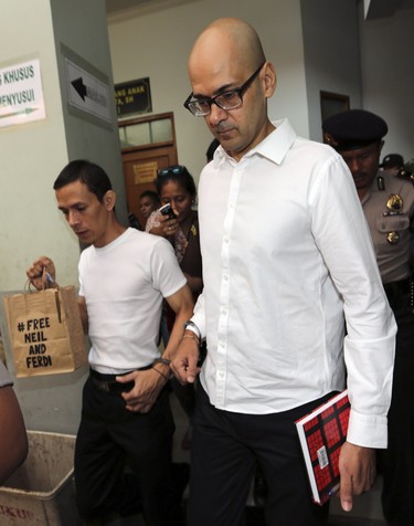 Canadian teacher Neil Bantleman, right, walks with Indonesian teaching assistant, Ferdinand Tjiong prior to the start of their trial hearing.