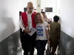 Neil Bantleman)comforts his wife Tracy after a court hearing in Jakarta on Tuesday. Bantleman's bid to have his abuse case thrown out was rejected by the South Jakarta District Court.