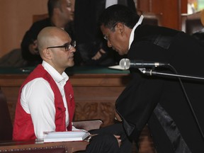 Canadian teacher Neil Bantleman, left, consults with his attorney Hotman Paris Hutapea prior to the start of a Dec. 2 hearing in Jakarta.