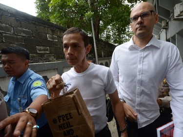 Canadian teacher Neil Bantleman, right, and Indonesian teaching assistant Ferdinand Tjiong, middle, arrive at the South Jakarta court prior to their trial in Jakarta on Dec. 2.