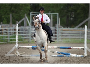 LONGVIEW, ; JULY 7,  2014  - Cait McLean clears a jump with her horse Winchester on Sunday at a Sidesaddle Clinic held at the Bar U on July 6, 2014. It is a chance for women to learn the skills involved in the traditional equestrian art of riding sidesaddle.