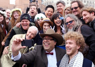 Calgary Mayor Naheed Nenshi takes a selfie with some of the actors after The Parade of Wonders in Calgary during the start of the Calgary Comic and Entertainment Expo.