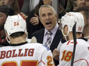 Calgary Flames coach Bob Hartley, center, talks to his team during the first period of an NHL hockey game against the Chicago Blackhawks in Chicago, Wednesday, Oct. 15, 2014.