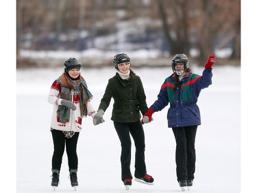 Calgary's Bailey Bjolin, left, joined her friends sisters Vanessa Urschel, centre, and Sydney Urschel taking a skate around the newly reopened skating pond on the Bowness Park Lagoon on December 25, 2014.