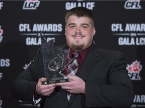 Brett Jones, of the Calgary Stampeders, celebrates his award for most outstanding offensive lineman during the CFL Awards in Vancouver last month.