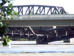 Train cars sat on the collapsing bridge after the train derailed on the Bonnybrook rail bridge on June 27, 2013.