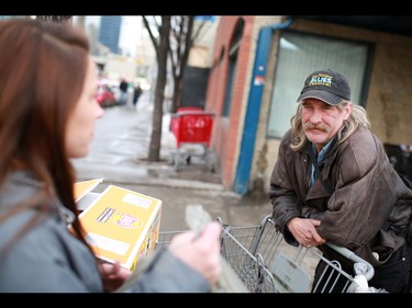 Tanya Richer talks with bottle collectors outside the Uptown Bottle Depot in Calgary's beltline while the handing out small food hampers on December 9, 2014.