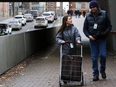 Tanya Richer, left and John Chief Moon, coordinators with the Canadian Mental Health Associations' Street Outreach and Stabilization (SOS) team, walk through a downtown underpass as they distribute small food hampers to make connections with those living on the street and convince them access the help and services that the organization can provide.