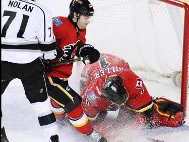 The Calgary Flames' Raphael Diaz protects goaltender Jonas Hiller during from the Los Angeles King's Jordan Nolan during third period NHL action in Calgary. The Flames won 2-1.