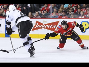 The Calgary Flames' Curtis Glencross stretches to reach the puck as the Los Angeles Kings' Matt Greene skates up ice during third period NHL action in Calgary. The Flames won 2-1.