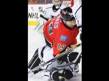The Calgary Flames' David Jones lands on the King's Alec Martinez during first period NHL action in Calgary.