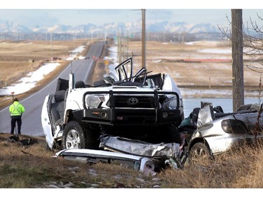 An RCMP officer takes measurements at the scene of a serious 2 vehicle crash on Township Road 254, Country Hills Boulevard, and the Conrich Road Friday morning December 12, 2014.