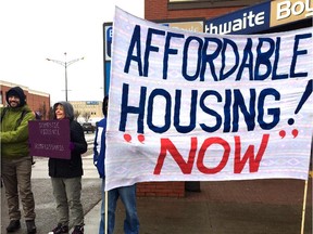 A Calgarian holds up a sign at a rally at 1701 Centre Street N.W. on December 13, 2014, to raise awareness about the city's housing crisis.